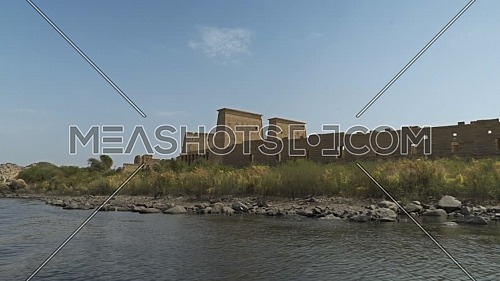 reveal shot for Temple of Philae li from the boat in the River Nile at Aswan - Egypt by day