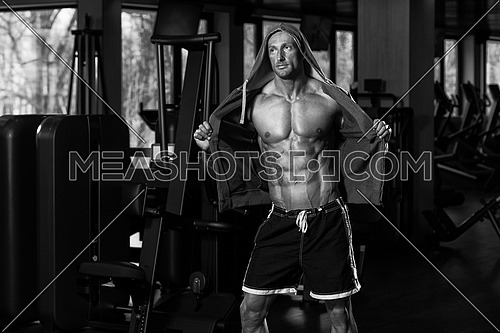 Portrait Of A Physically Fit Man In Hoodie - In Modern Fitness Center - Showing His Six Pack - Black And White Photo