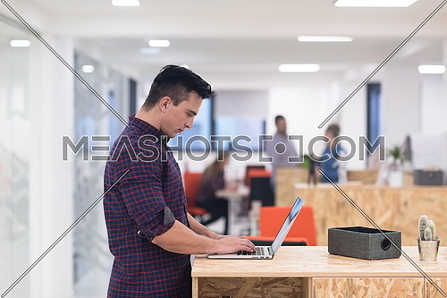 portrait of young businessman in casual clothes at modern  startup business office space,  working on laptop  computer