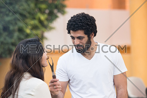Young middle eastern couple preparing a barbecue for friends summer evening and enjoy it