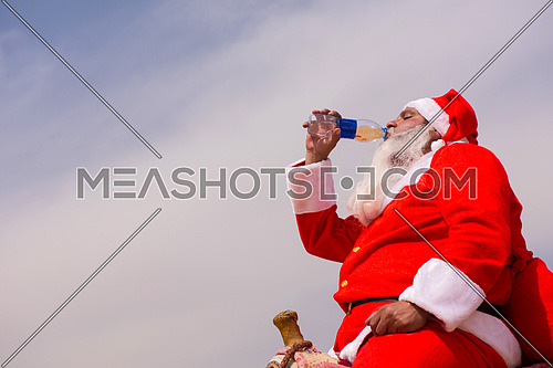 santa claus drinking water in the desert heat