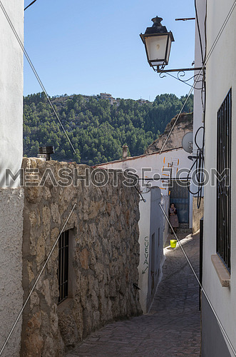 Alcala del Jucar, Spain - October 29, 2016: Narrow street with white painted houses, typical of this town, take in Alcala of the Jucar, Albacete province, Spain