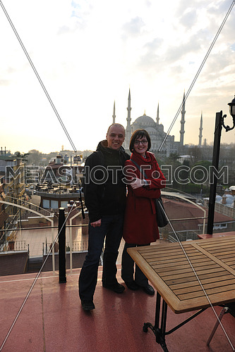 happy young couple portrait outdoor at sunny day in istanbul turkey with beautiful old mosque with sunset in background