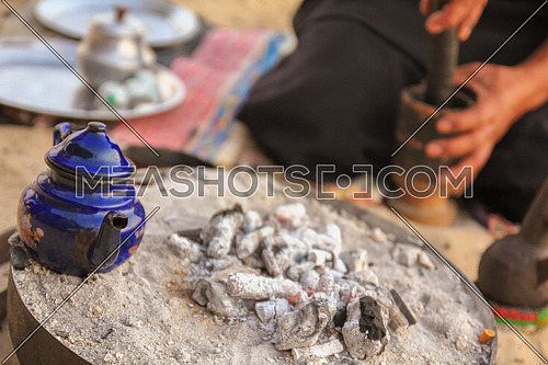 Gringing traditional Gabana Coffee and a kettle of tea on charcoal