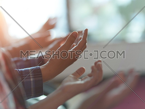 group of muslim people praying namaz  in mosque together closeup on hands