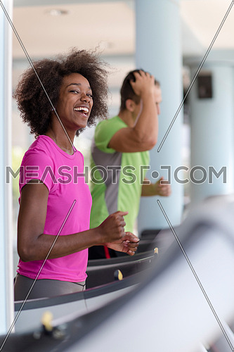 young people exercisinng a cardio on treadmill running machine in modern gym