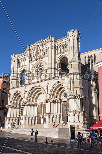 CUENCA, SPAIN - APRIL 2, 2016: Tourists walk near the facade of the Cuenca's Cathedral, The cathedral is dedicated to St Julian, gothic english-norman style, XII century, called the Basilica of Our Lady of Grace