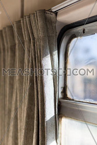 Touristic train in Egypt from Cairo to Aswan. A fuzzy window and curtains are open. Close up