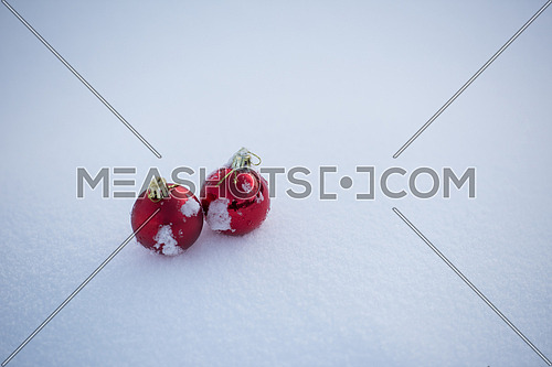 christmas red balls decoration in fresh snow background on beautiful sunny winter day