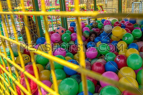 Egyptian kids playing inside a ball den in amusement park during eid al fitr celebration