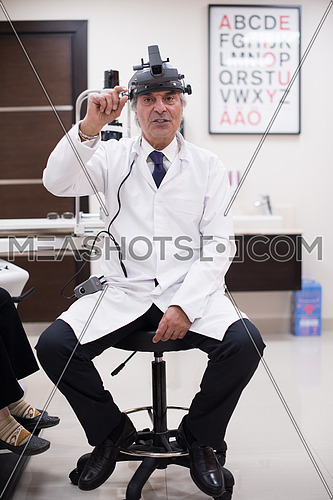 portrait of an elderly middle eastern ophthalmologist in his office in the modern clinic