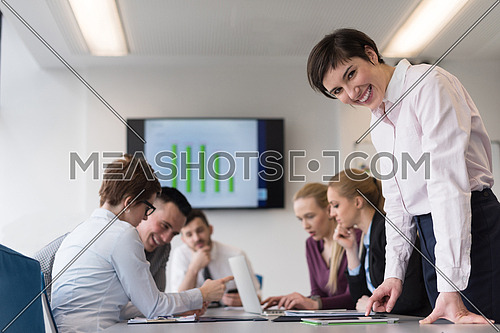 young businesswoman in casual hipster clothes working on tablet computer at modern startup business office, people group working and brainstorming in background