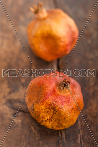 dry and old pomegranates over rustic wood table