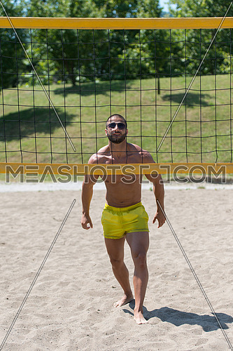 Muscular Young Man Playing Beach Volleyball Diving After The Ball