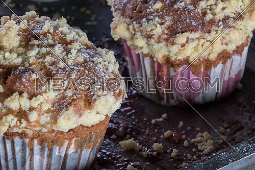Muffins with crumbs on a tray moist with jam
