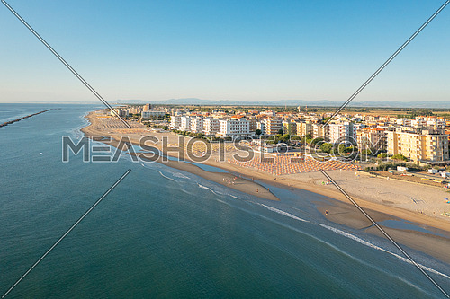 Aerial shot of sandy beach with umbrellas and gazebos.Summer vacation concept.Lido Adriano town,Adriatic coast, Emilia Romagna,Italy.