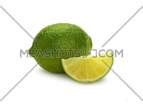 Close up one whole fresh green lime fruit and cut slice wedge, isolated on white background, low angle side view
