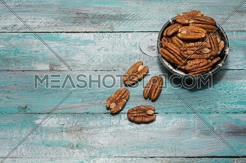 Tasty pecan  in  bowl on the old background.