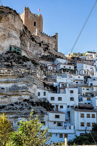 Alcala del Jucar, Spain - October 29, 2016: Side view of the village, on top of limestone mountain is situated Castle of the 12TH century Almohad origin, take in Alcala of the Jucar, Albacete province, Spain
