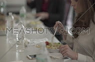 Awoman eating salad during a meeting break