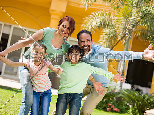 portrait of a happy middle eastern family in the yard of a beautiful sunny day