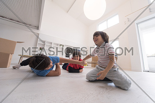 happy young boys having fun with an apple on the floor in a new modern home