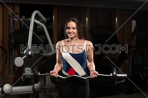 Young Woman Doing Heavy Weight Exercise For Biceps
