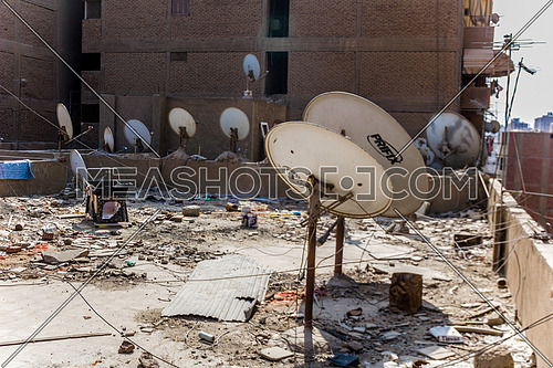 Long shot for messy Roof of Egyptian House with a lot of satellite dishes at day