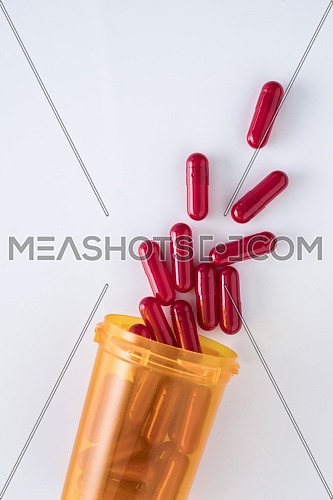 capsules going out of a bottle, conceptual image, vertical composition