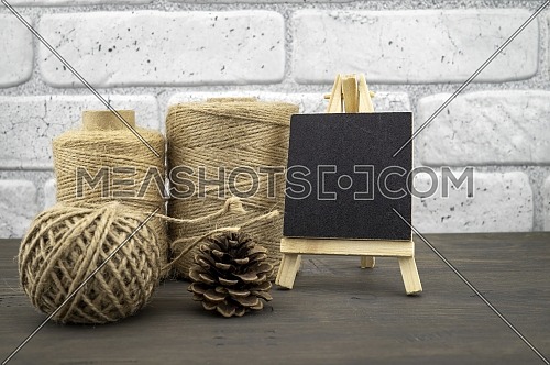 Assorted balls of hemp twine and slate chalkboard in a close up rustic still life