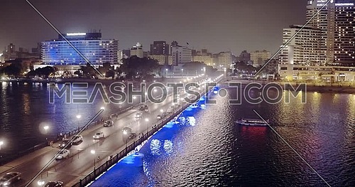 Drone getting down to the River Nile revealing The Nile Ritz Carlton Hotel, Kasr Al Nile Bridge and Semiramis Hotel at night