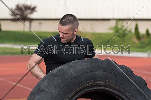 Young Man Turning Tire Over - Bodybuilding Exercises Truck Tire