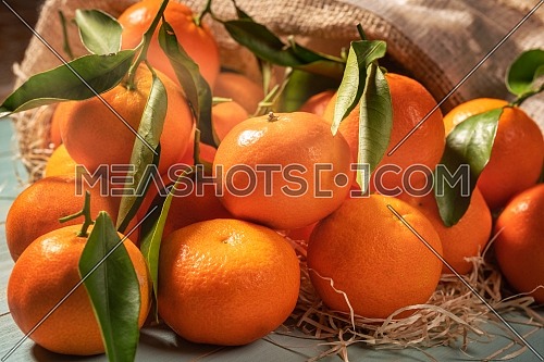 Fresh tangerines on blue wooden table.