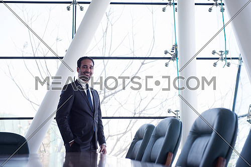 young businessman standing alone in modern conference room office