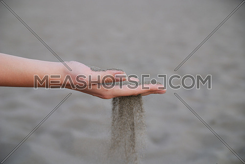 fine sand leaking trought woman hands