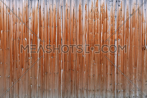 Close up background texture of old vintage brown weathered vertical knotted wooden plank fence or wall