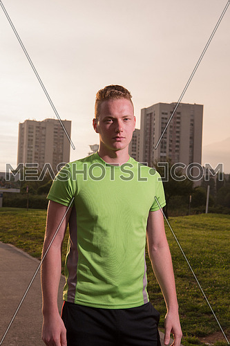 Young man looking at the rest of path during a break of his outdoor jogging training