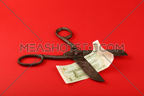 China financial crisis, decline of Chinese economy and yuan exchange rate illustrated, old vintage scissors cut one yuan banknote on red background
