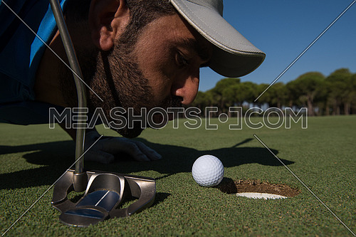 golf player blowing ball in hole. concept of cheating and success