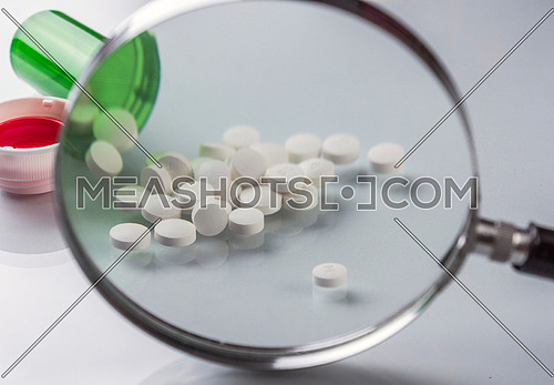 Pads white in a boat seen from a magnifying glass isolated in white background, conceptual image