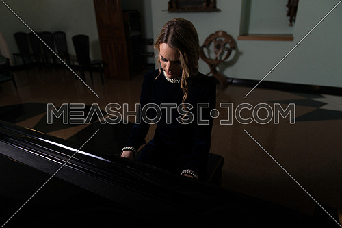 Beautiful Thoughtful Girl Sitting Near Piano - Fashion Studio Portrait