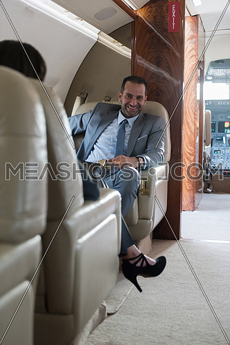 Young middle eastern successful businessman and businesswoman enjoy sitting in private jet