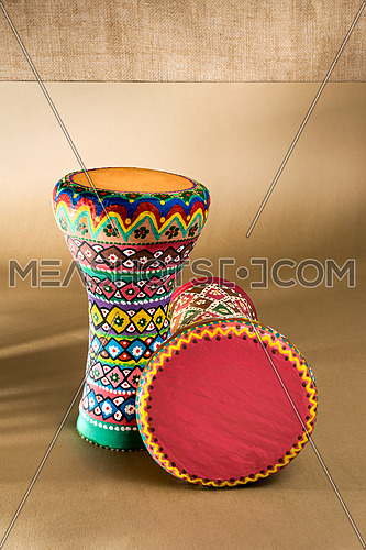 Two decorated colorful pottery goblet drums (chalice drum, tarabuka, darbuka) on background of wooden table with vanishing shadow lines
