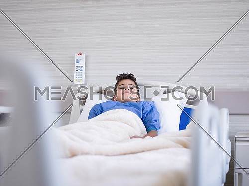 young boy patient lies in a hospital bed