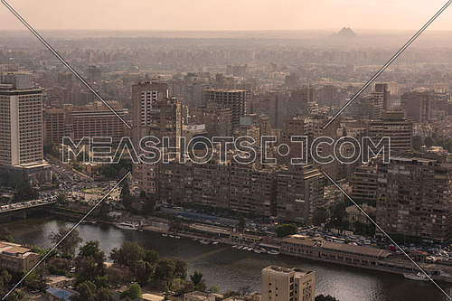 aerial view of giza city downtown with Nile and pyramids in the distance at beautiful sunny day with blue sky and clouds capital of Egypt