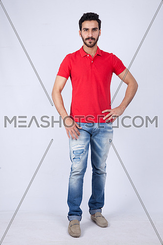 A young man wearing red t-shit posing on a white background