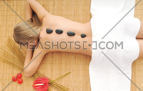 young healthy woman in wellness and spa studio have Massage with hot volcanic stones