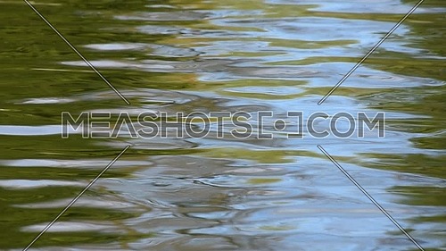 Colorful abstract background of blue and green ripples and waves running on water surface, moving flow background