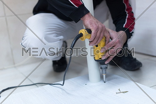 repairman working with drilling machine and assambling  furniture