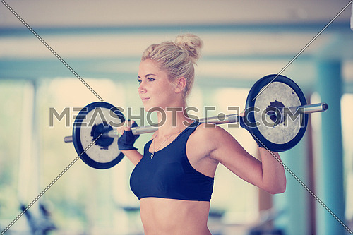 healthy and fit young woman in fitness gym lifting weights and working on her butt muscles